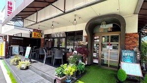 Restaurante com mesas ao ar livre e placa de café.