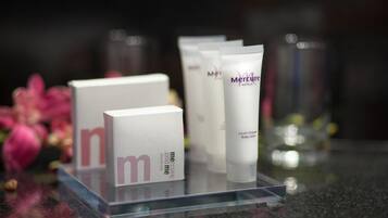 A display of Mercure Hotels body lotion products on a clear stand.