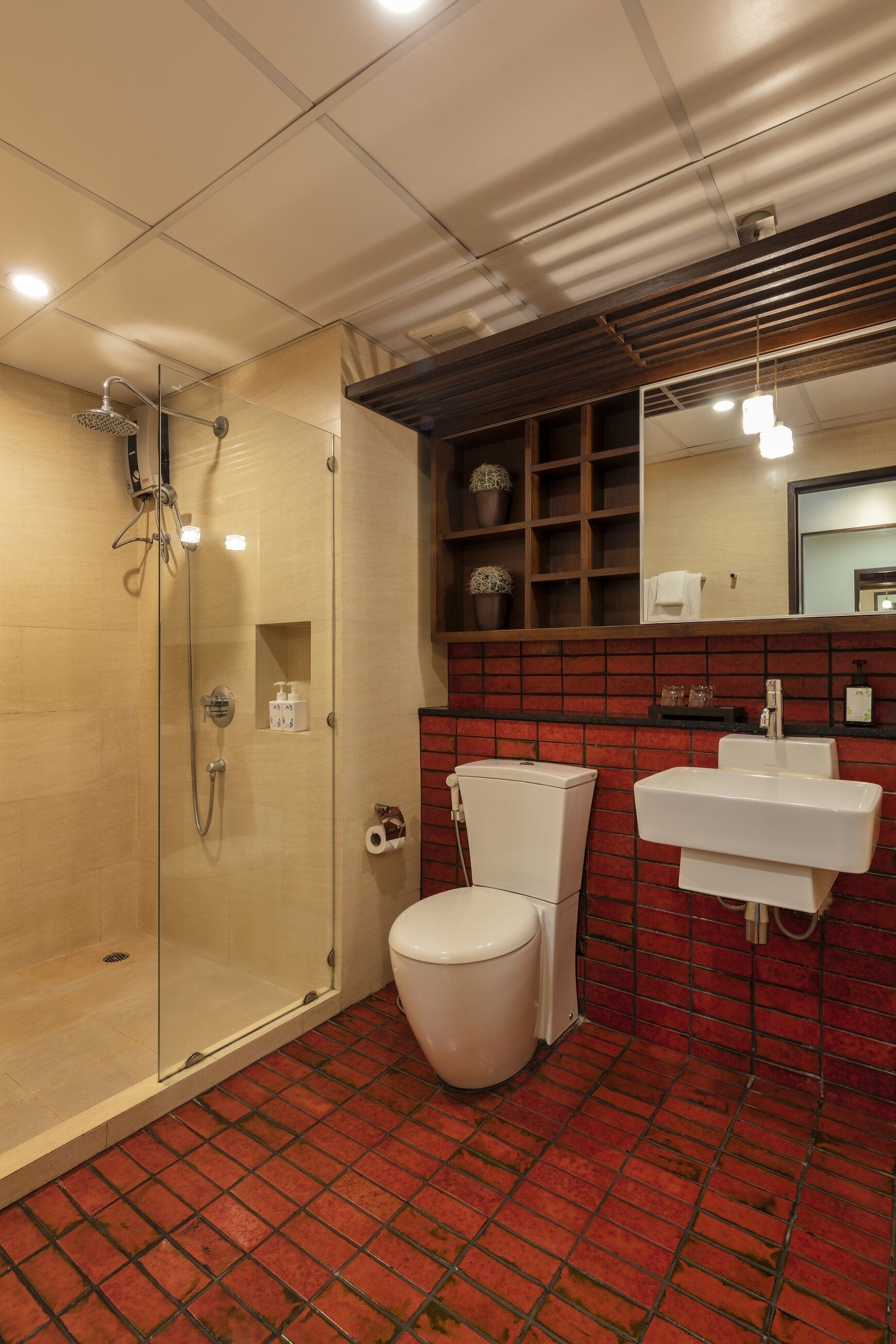 Een badkamer met een douchecabine van glas, een wit toilet en een wastafel.