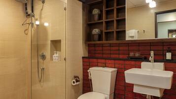Een badkamer met een douchecabine van glas, een wit toilet en een wastafel.