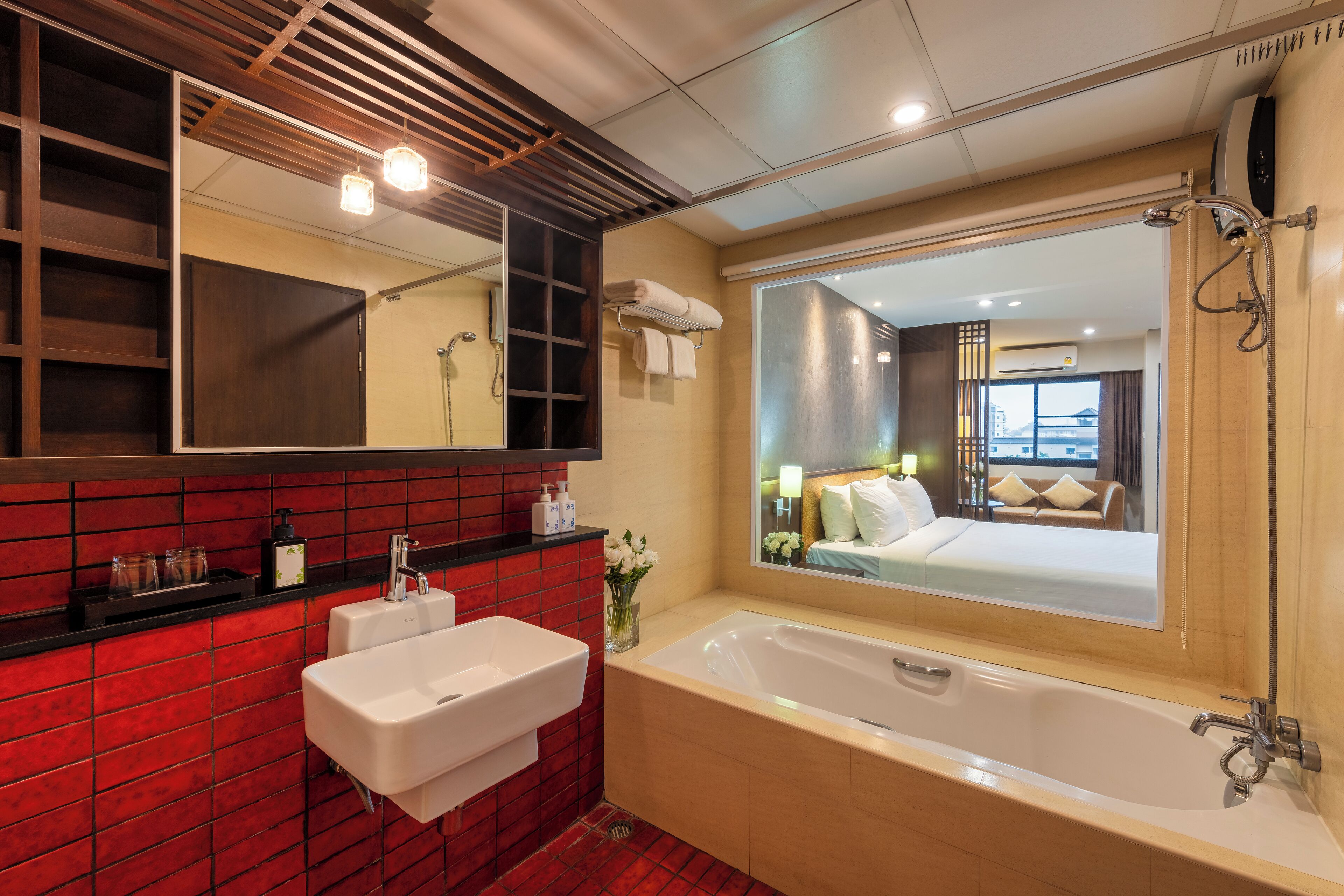 A modern bathroom with a large mirror, a bathtub, and a sink.