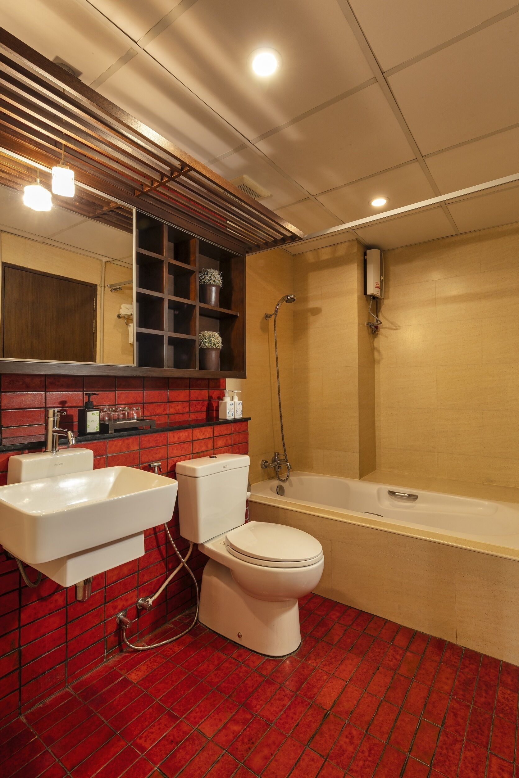 A modern bathroom with a red-tiled floor, a white sink, a toilet, and a bathtub.