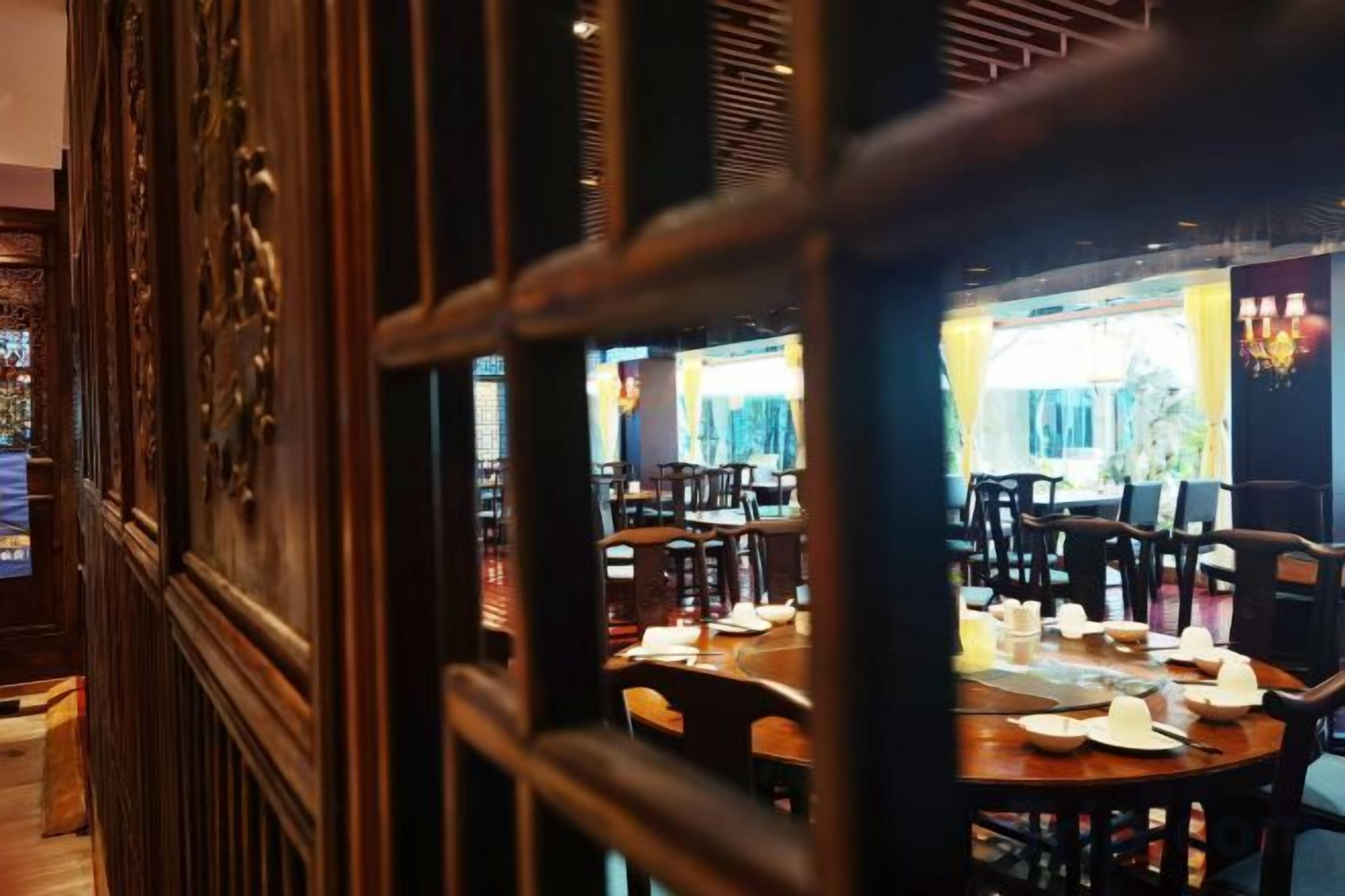 A restaurant interior with wooden furniture and a view of the street outside.