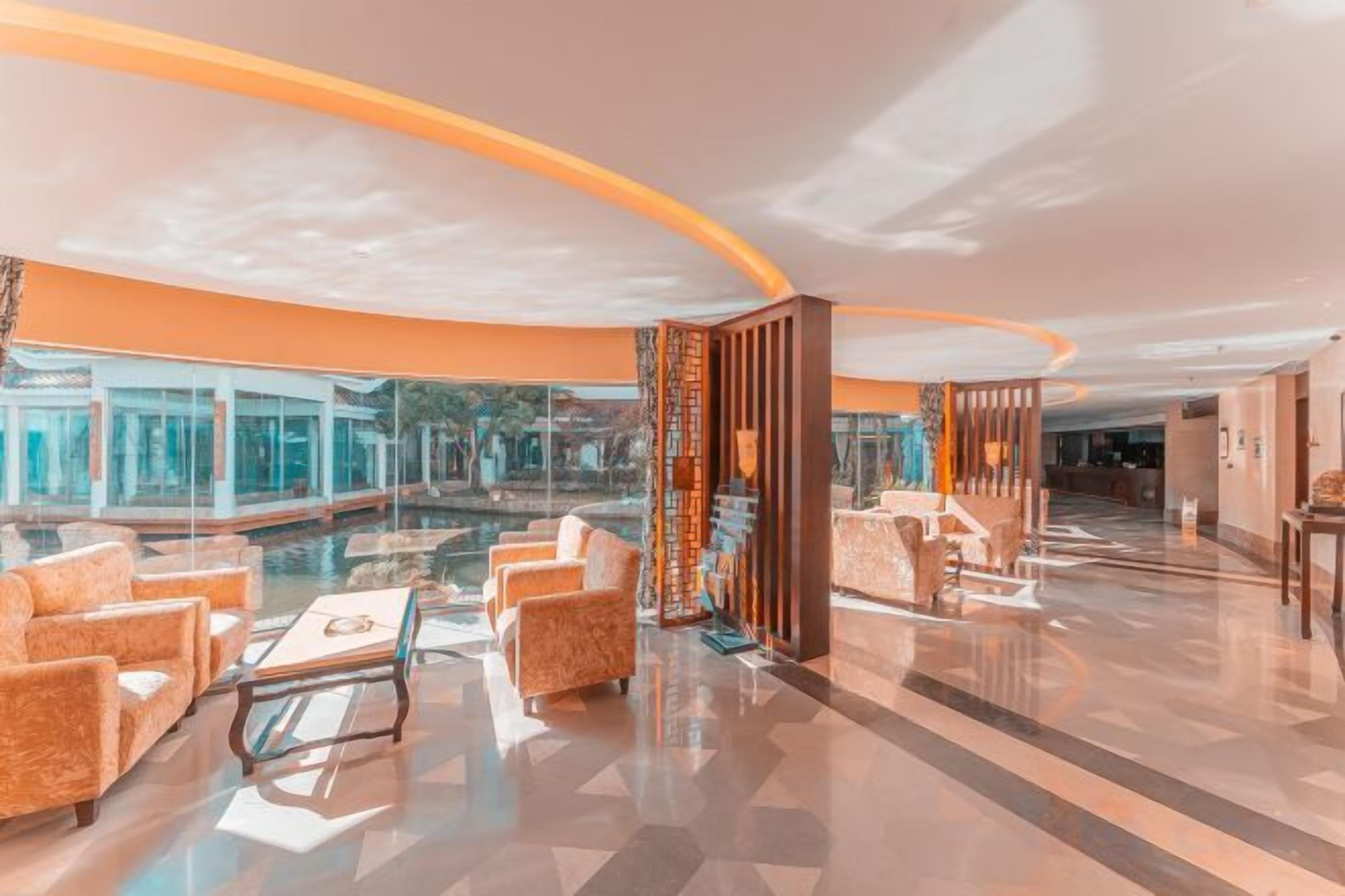 A spacious lobby with a pool, seating area, and a reception desk.