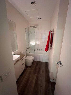 A bathroom with a toilet, sink, and shower.