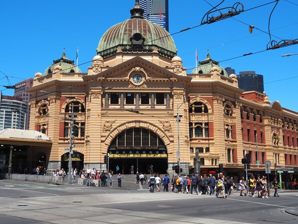 A historic building with a prominent dome and arched entrance, surrounded by a busy street scene.