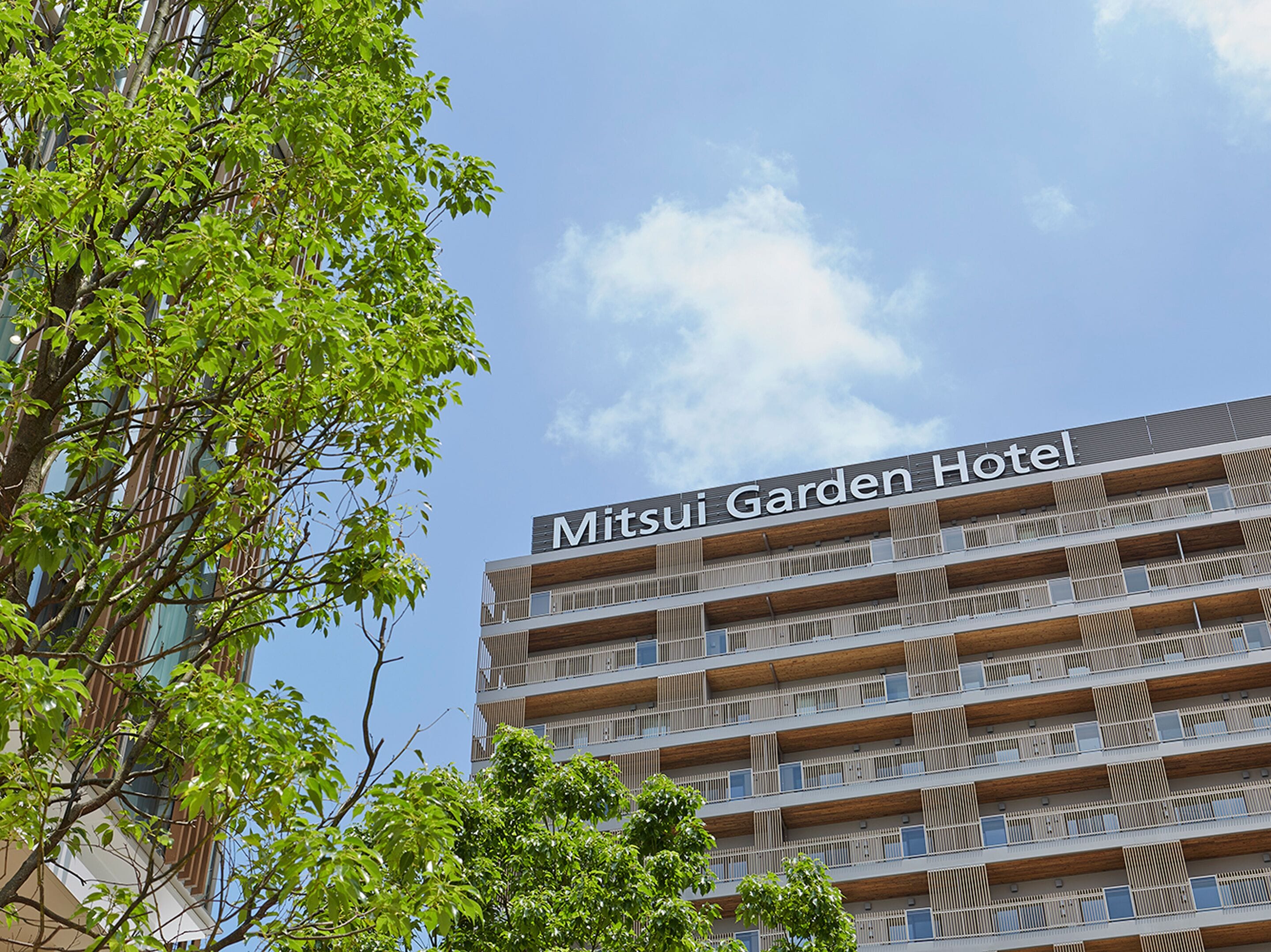 A multi-story hotel building with a sign reading 'Mitsui Garden Hotel.'