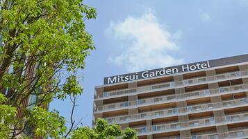 A multi-story hotel building with a sign reading 'Mitsui Garden Hotel.'