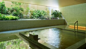 Un área de piscina interior tranquila con vistas despejadas a la vegetación circundante y un suelo de baldosas.
