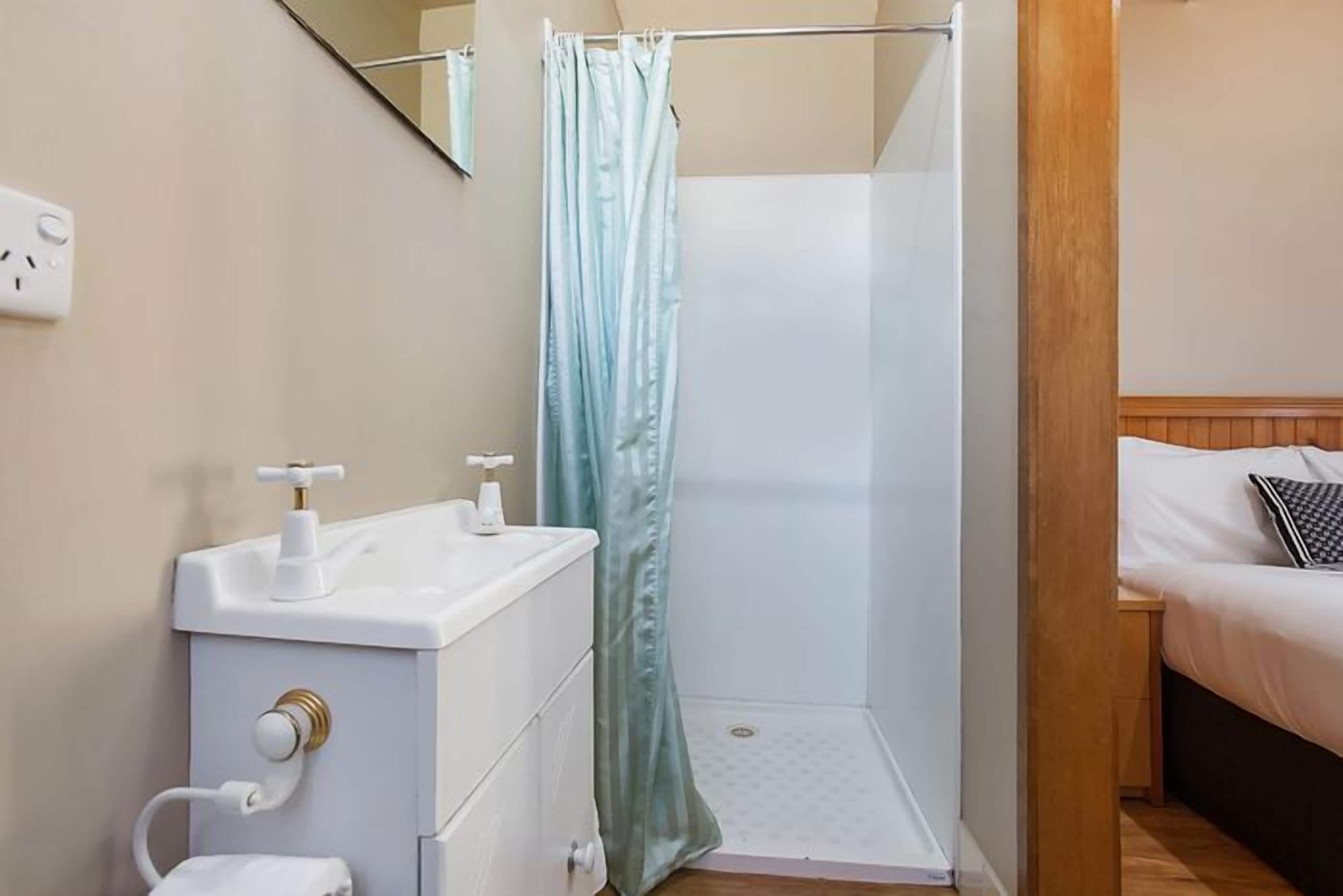 A bathroom with a shower, toilet, and sink.