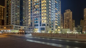 Un hotel de gran altura con múltiples balcones, señalización iluminada y un llamativo letrero que dice 'City Premiere'.