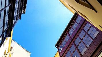 A narrow street with buildings on either side, featuring a clear blue sky above.