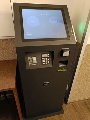 A self-check-in kiosk with options for check-in and check-out, credit card and key card payment, and a contactless payment option. - Hotel Zlatá Váha (Prague)