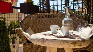 A wicker chair with a small table, a bottle, and a cup. - Casale D'Or (Palermo)
