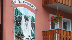 A hotel sign with a waterfall painting and a dog illustration. - Garní al Nardis (Carisolo)