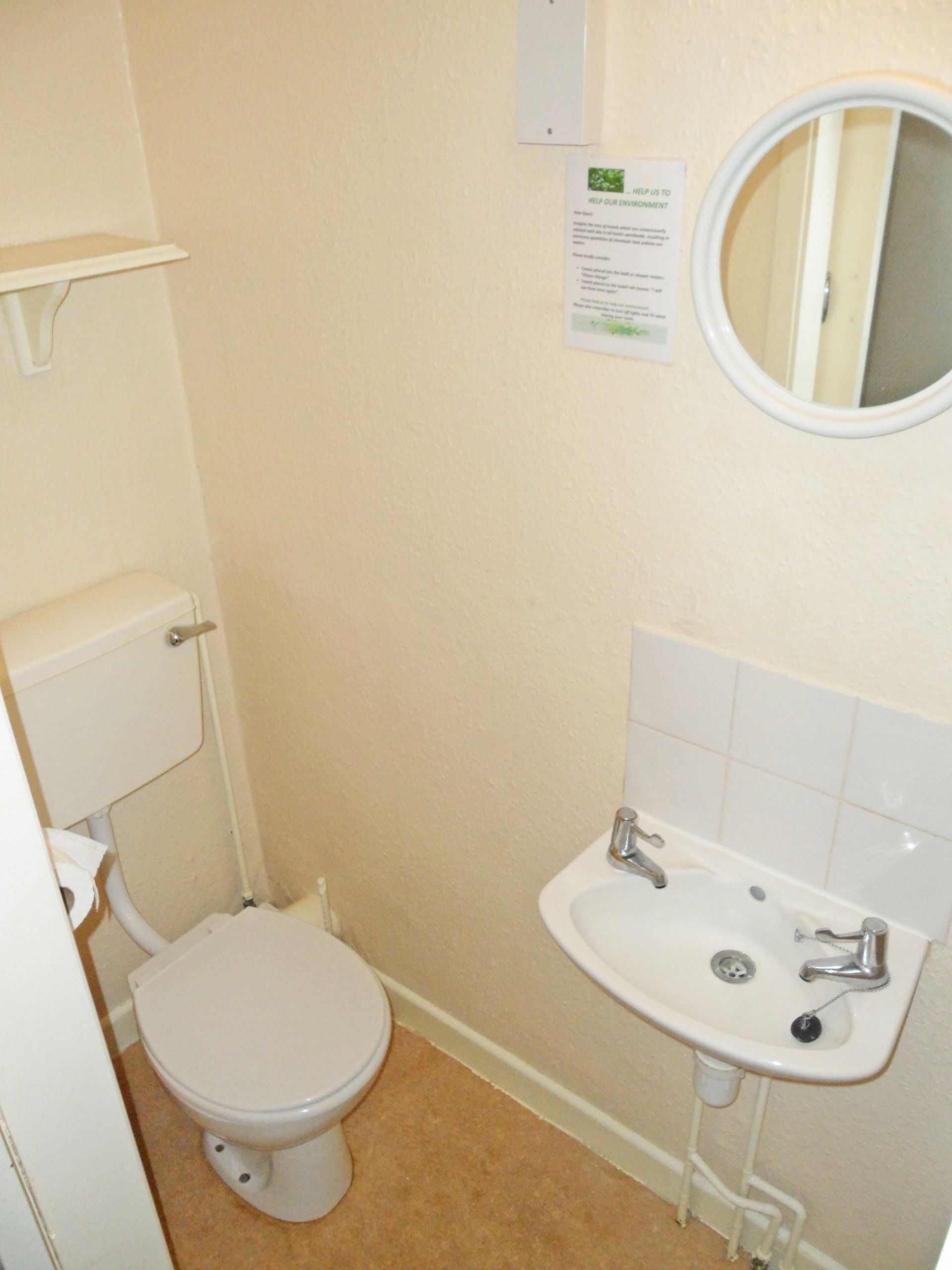 Un baño pequeño y limpio con inodoro, lavabo y espejo.