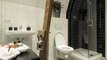 A modern bathroom with a white sink, toilet, and glass-enclosed shower.
