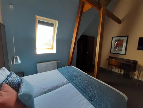 A bedroom with a bed, a window, a desk, and a chair. - Hotel De Villa (Dongen)