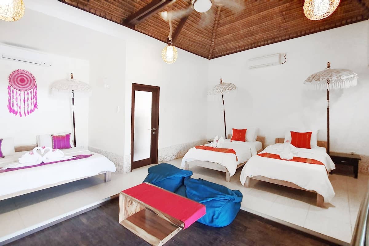 Habitación de hotel con dos camas, techo de madera y adornos en las paredes.