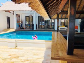Una piscina al aire libre, sillones reclinables de piscina