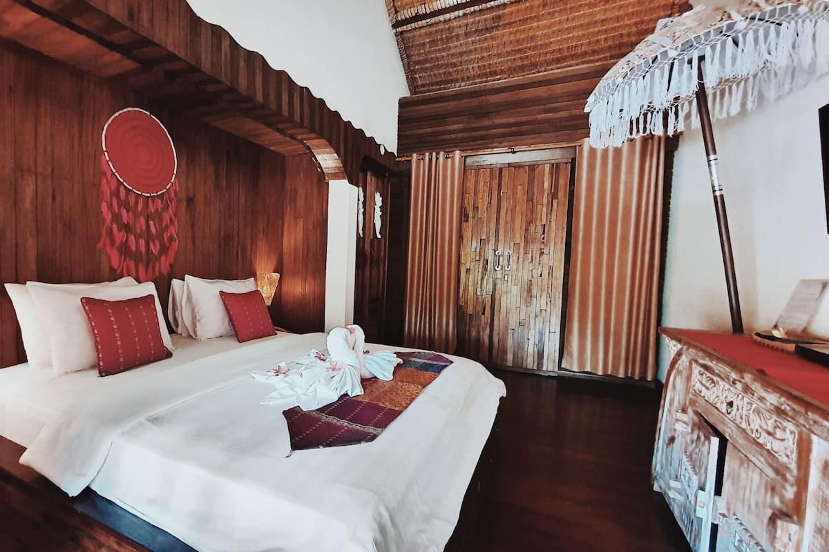 Un dormitorio de estilo rústico con una cama, almohadas y un adorno en la pared.
