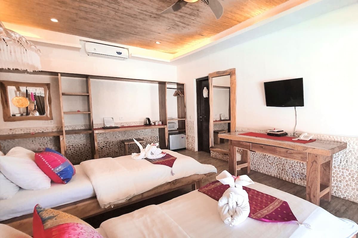 Una habitación de hotel con una cama, un escritorio, un televisor y un espejo.