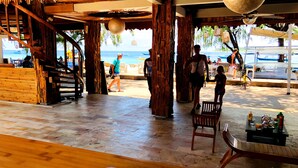 A wooden outdoor seating area with a view of the beach and ocean.