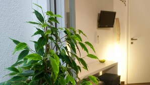 A potted plant on a white floor next to a white door. - B&B Carella (Palermo)