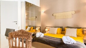 A hotel room with a bed, bedside tables, a mirror, and a stone wall. - B&B Carella (Palermo)