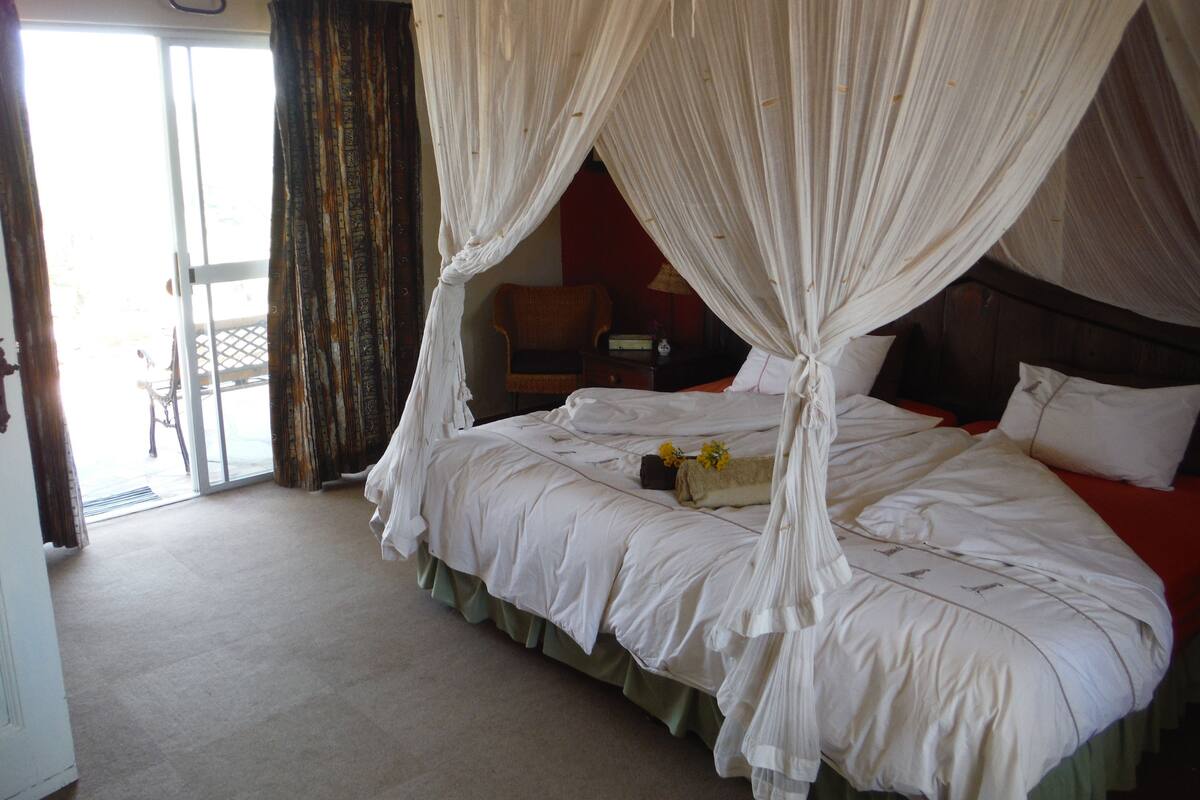 A room with a bed, a chair, and a table.