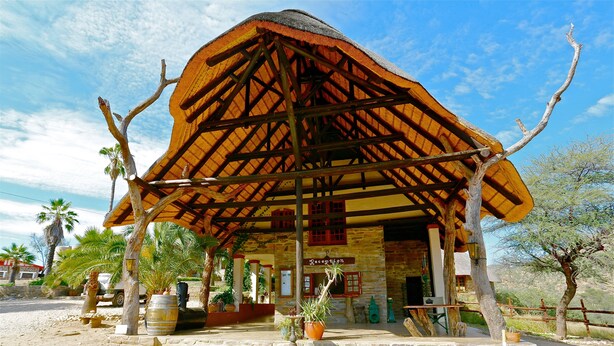 A rustic building with a thatched roof, stone walls, and a sign reading "Reception".