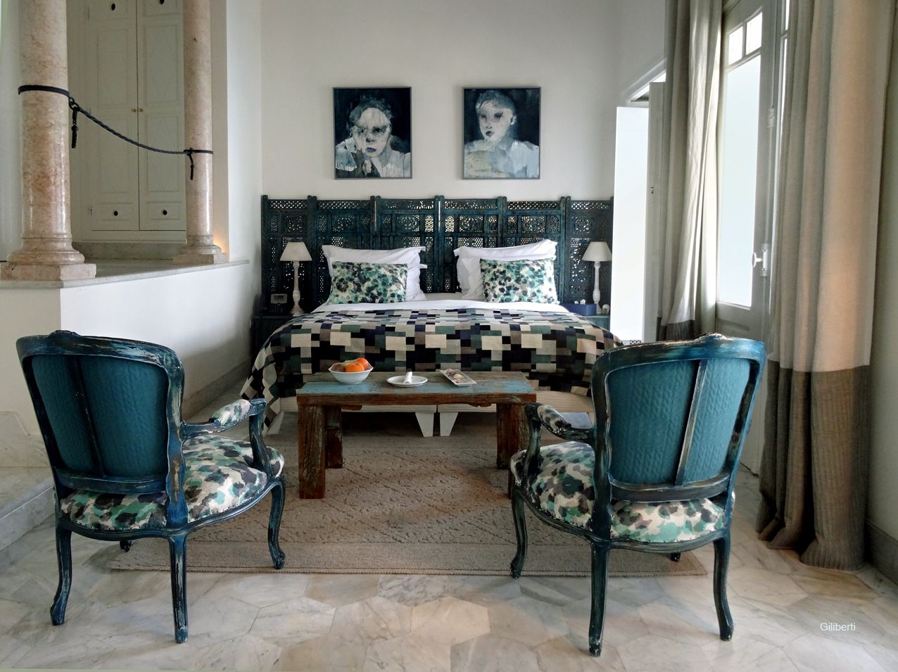 Ein Schlafzimmer mit einem Bett, zwei Sesseln, einem Couchtisch und einem Kopfteil.