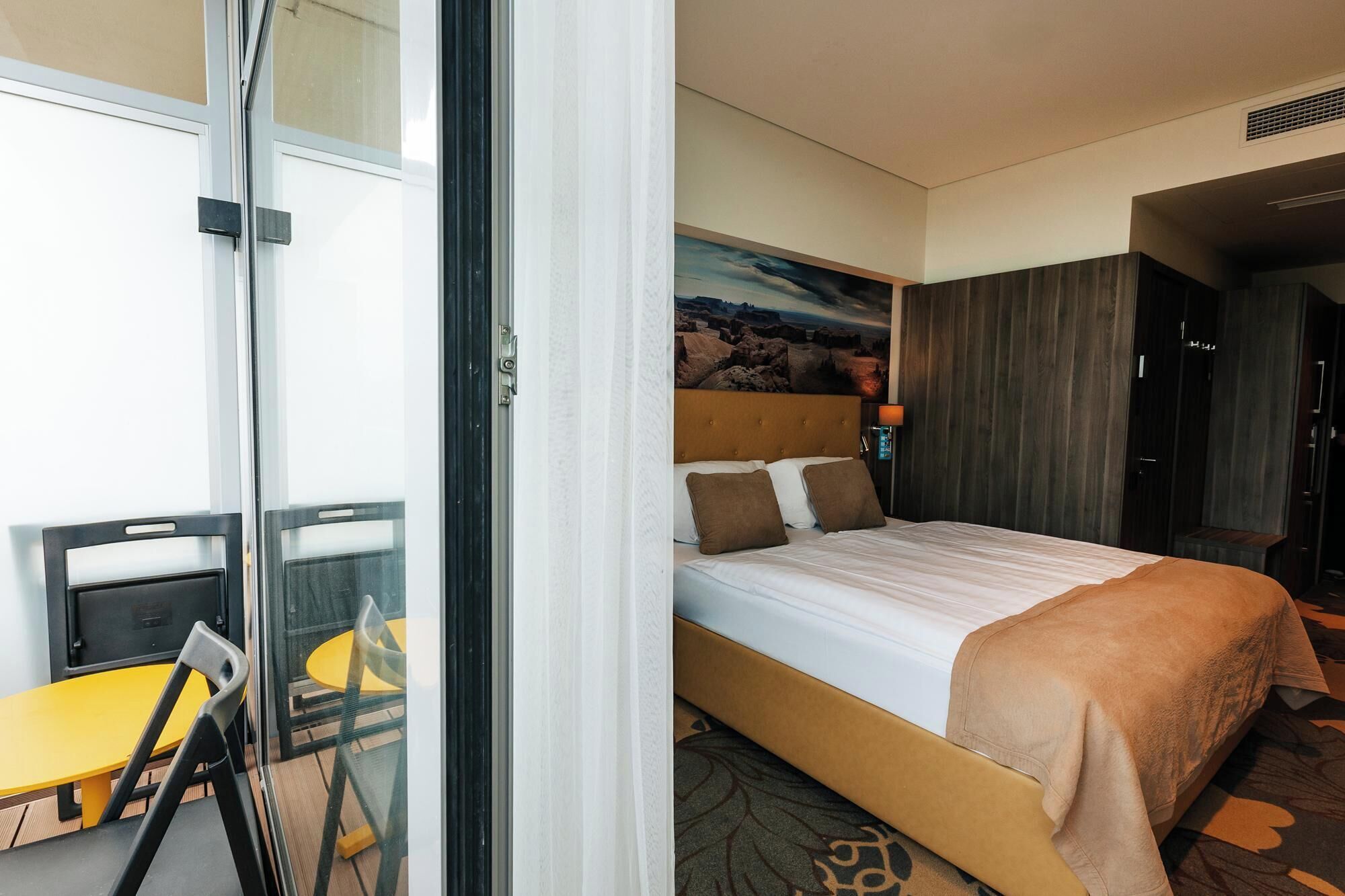 Een hotelkamer met een bed, een bureau en een stoel.