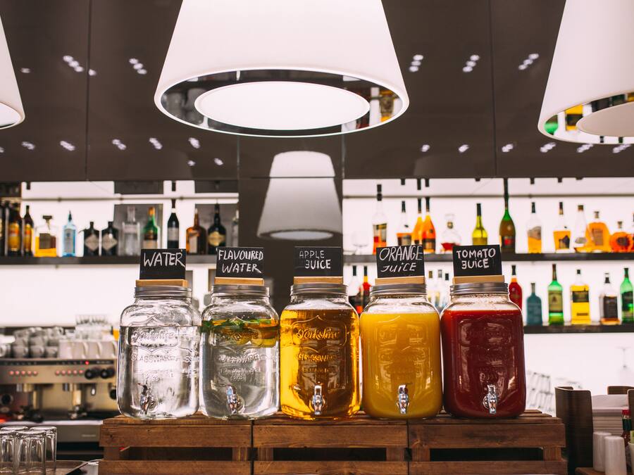 Un espace bar proposant une sélection de boissons servies dans des bocaux étiquetés avec leur nom.