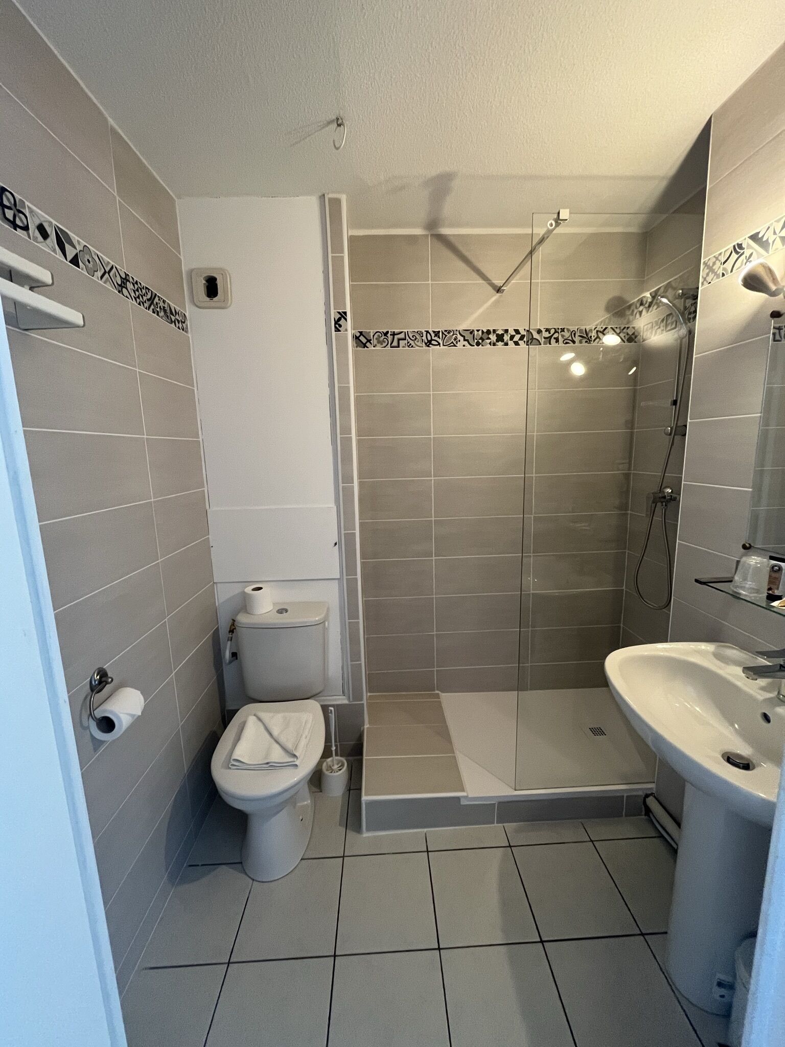 A bathroom with a toilet, shower, and sink.