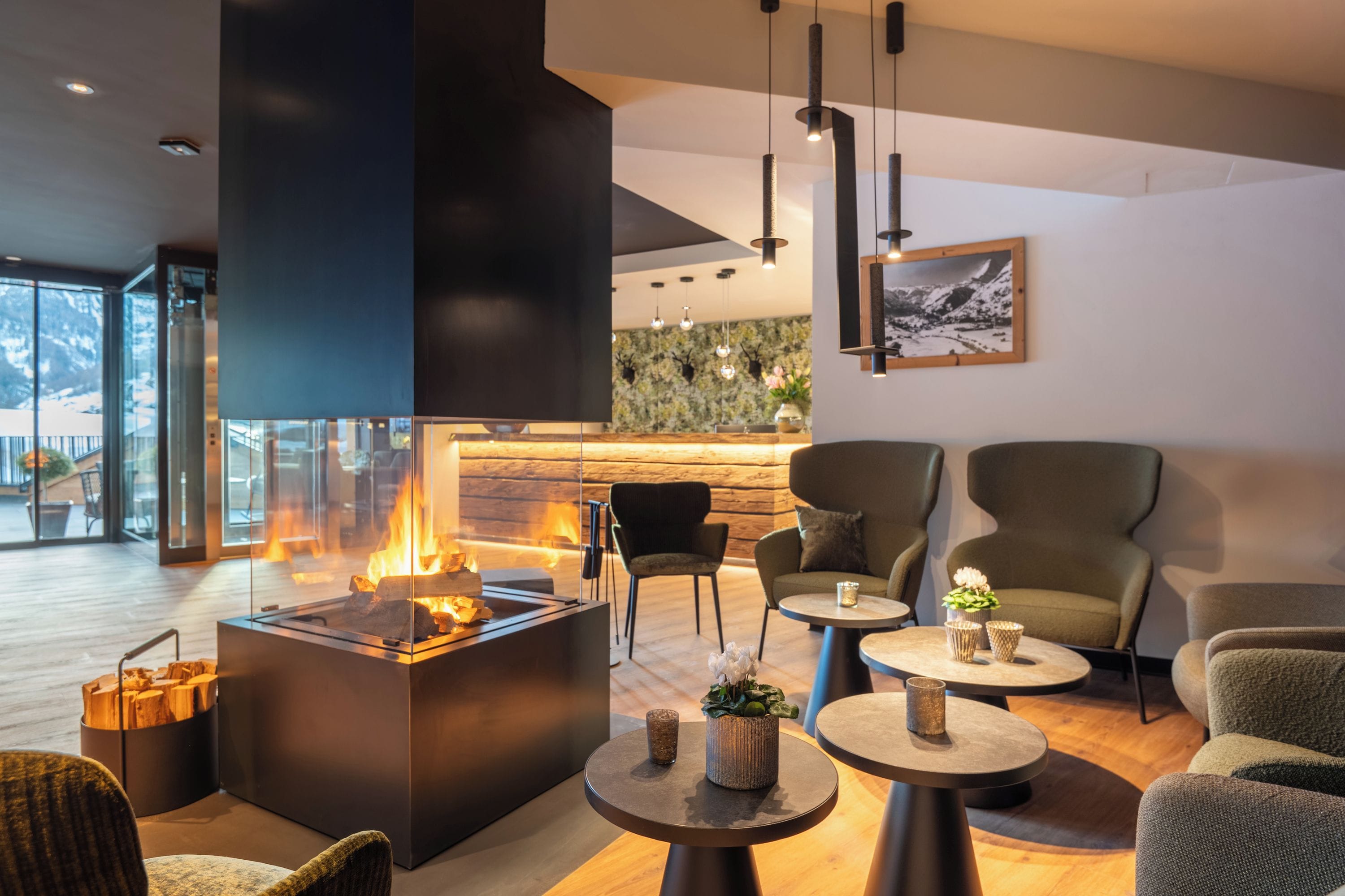 Un intérieur moderne avec une cheminée, un coin salon et une vue sur l’extérieur.