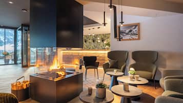 Un intérieur moderne avec une cheminée, un coin salon et une vue sur l’extérieur.