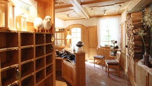 A wooden interior with a reception desk, a chair, and a shelf with keys. - Hotel Welschen Zermatt (Zermatt)
