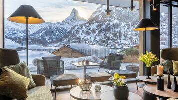 Ein gemütlicher Sitzbereich mit Blick auf schneebedeckte Berge.