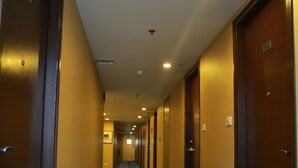 A hotel hallway with patterned carpet, wooden doors, and recessed lighting. - Jubilee Ridge (Hyderabad)