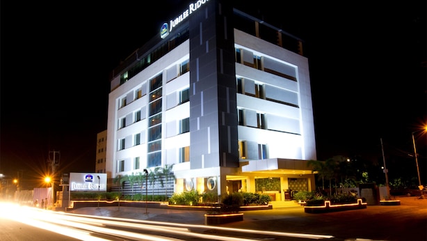 A modern hotel with a prominent sign, multiple floors, and a well-lit entrance. - Jubilee Ridge (Hyderabad)