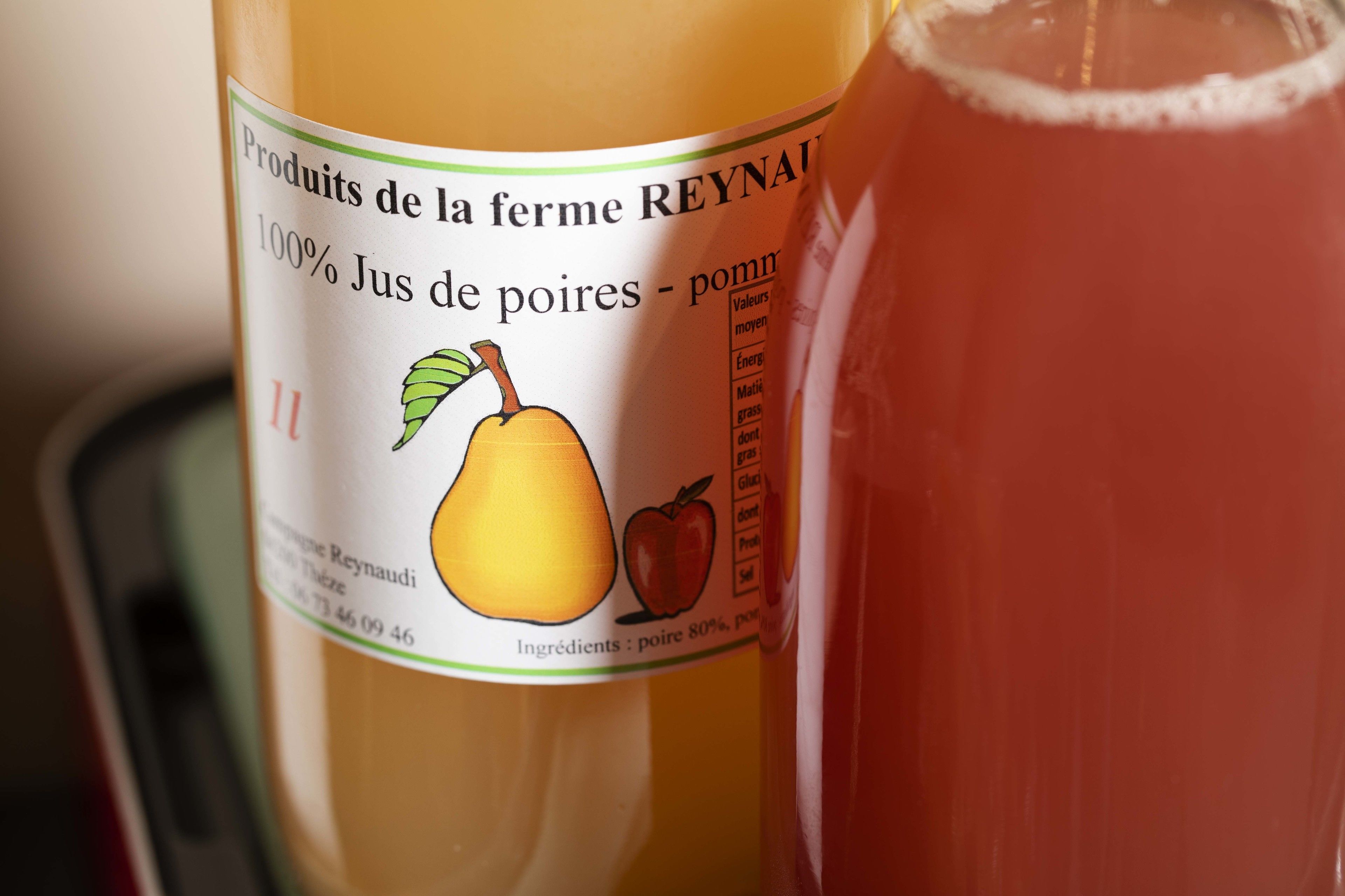 En flaske pærejuice med etikette der angiver, at det er 100% juice fra pærer.