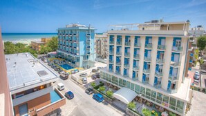 Un hôtel à plusieurs étages, doté de balcons et d’un espace piscine.