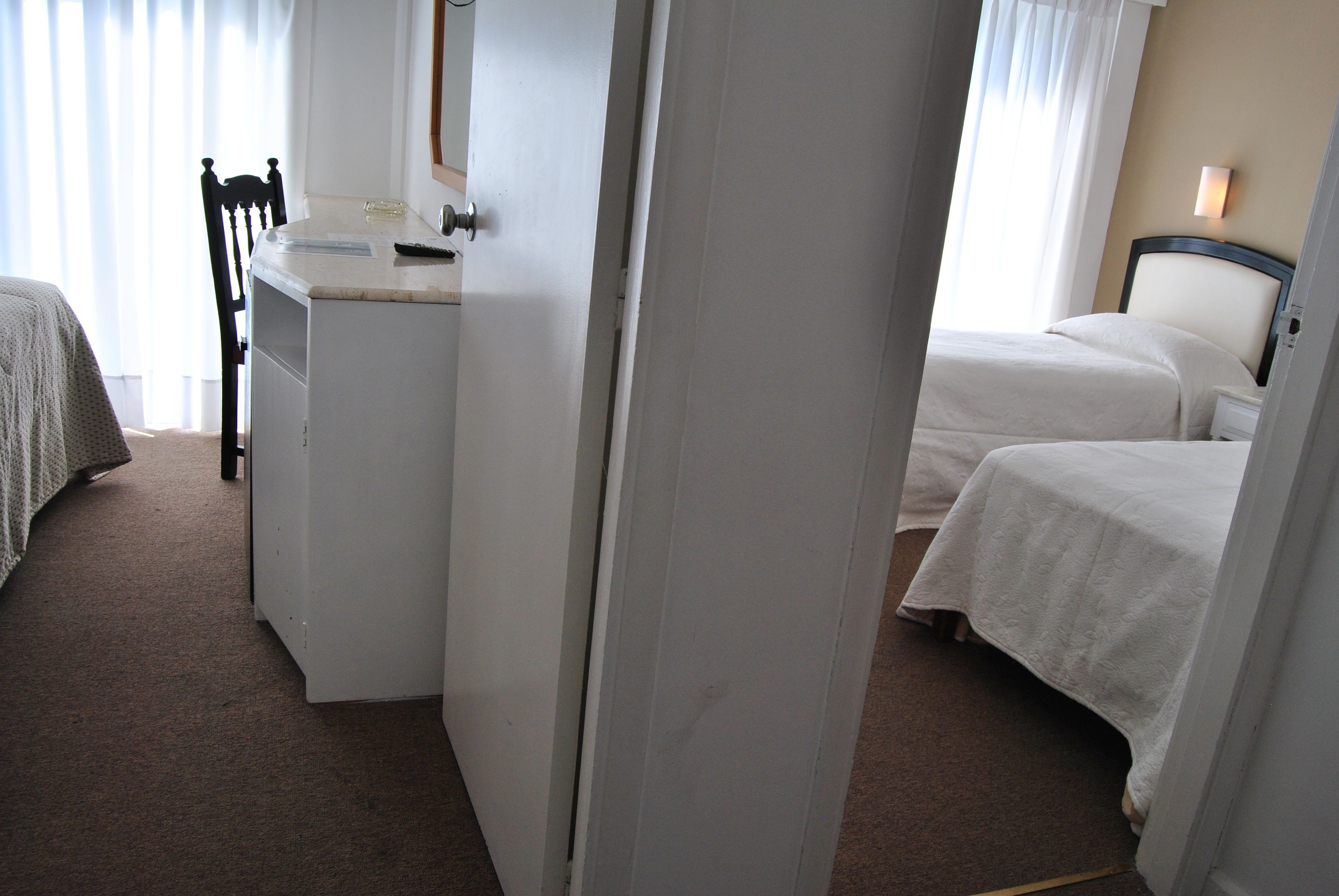 Una habitación de hotel con una cama, un escritorio y una silla.