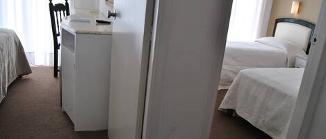 Una habitación de hotel con una cama, un escritorio y una silla.