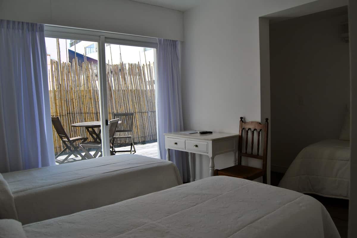 Una habitación de hotel con dos camas, un escritorio y una silla.