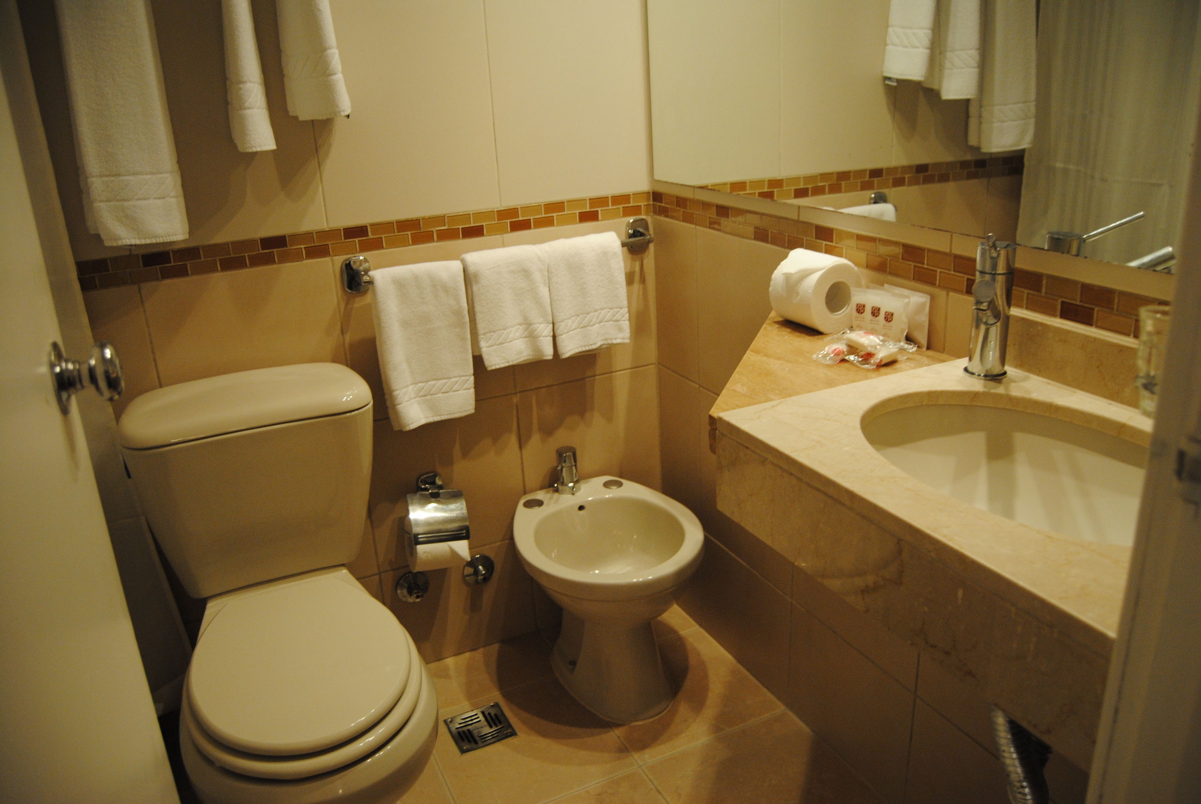 A standard bathroom with a toilet, bidet, and sink.