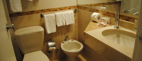 A standard bathroom with a toilet, bidet, and sink.