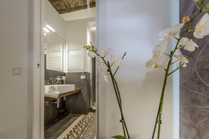 A modern bathroom with a mirror, sink, and patterned floor tiles. - First Floor (Rome)