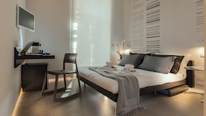 A modern bedroom with a bed, desk, chair, and a wall with text and numbers. - First Floor (Rome)